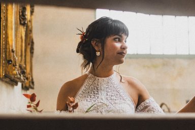 Femme avec une coiffure élégante, portant une robe blanche, regardant au loin.